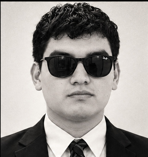 Retrato de Antonio Hernández con traje negro y gafas oscuras